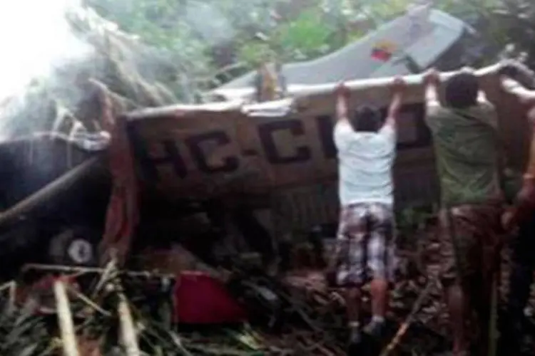 Várias pessoas tentam ajudar no resgate das vítimas do acidente aéreo na Amazônia equatoriana
 (Ho/AFP/AFP)