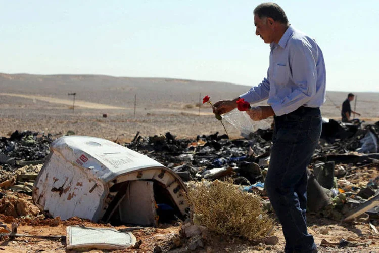 
	Homem coloca flores em local de queda: inicialmente, grupo havia planejado derrubar um avi&atilde;o de pa&iacute;s ocidental
 (Mohamed Abd El Ghany/REUTERS)