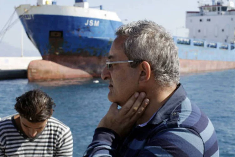 Ramez Haddad, capitão do cargueiro JSM, em frente ao navio ancorado depois que um tribunal da Grécia proibiu que ele partisse após um acidente mortal no porto de Kiato, na Grécia (Kostas Tsironis/Bloomberg)