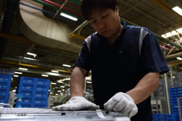 Funcionário da Visteon na linha de produção de ar-condicionados para carros (SeongJoon Cho/Bloomberg)