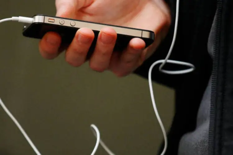 
	Homem usa um iPhone, da Apple: briga entre Apple e Google acabou
 (Brendon Thorne/Bloomberg)