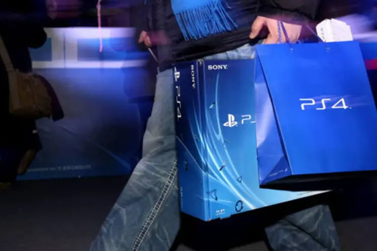 Consumidor carrega um recém comprado PlayStation 4 (PS4), da Sony, após evento de lançamento do console em Seul (SeongJoon Cho/Bloomberg)
