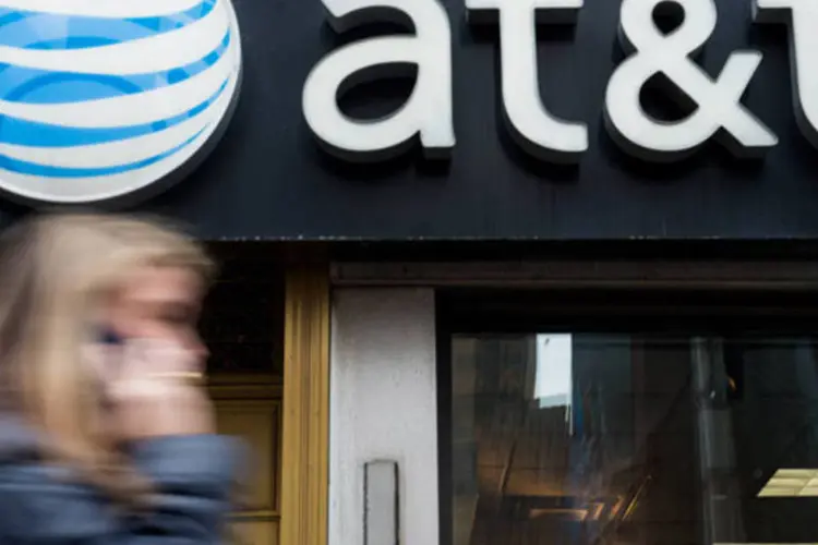 
	Mulher passa em frente a uma loja da AT&amp;T em Nova York
 (Craig Warga/Bloomberg)