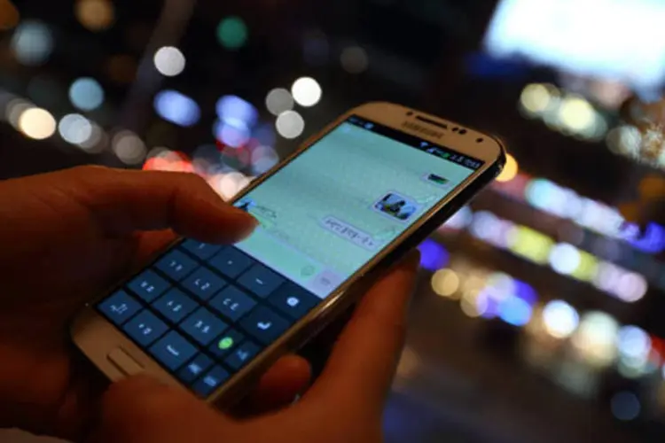 
	Mulher usa smarphone: 5G pode ser comercializado em 2020
 (SeongJoon Cho/Bloomberg)