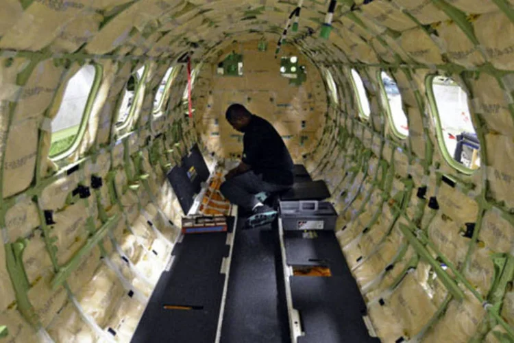 Técnico instala sistema de cabos elétricos em um jato executivo Phenom 300 Light fabricado pela Embraer em Melbourne, na Flórida (Mark Elias/Bloomberg)