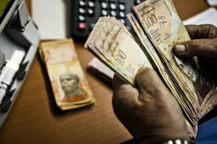 
	Dono de um restaurante conta notas de bol&iacute;vares em Caracas, na Venezuela
 (Meridith Kohut/Bloomberg)