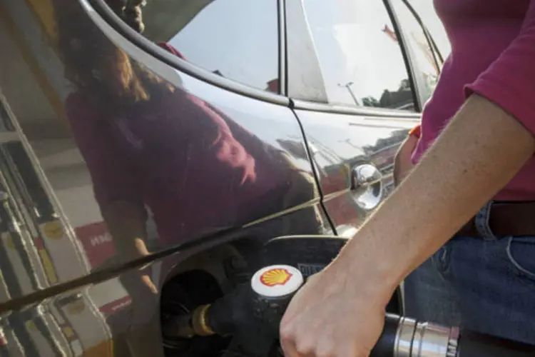 Mulher abastece veículo em um posto de Bruxelas: alta produção de xisto está evitando que preço do petróleo atinja máximas (Jock Fistick/Bloomberg)