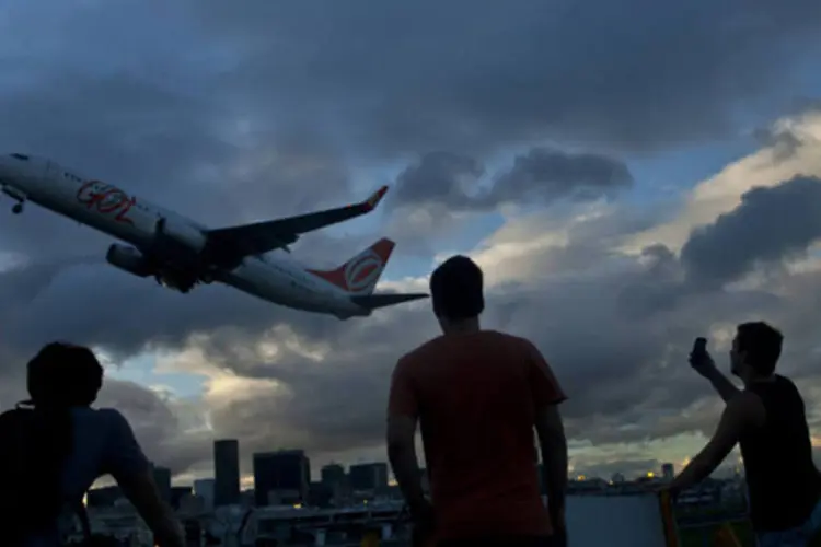 
	Pessoas olham um avi&atilde;o da GOL Linha A&eacute;reas decolando do Aeroporto Santos Dumont no Rio de Janeiro
 (Dado Galdieri/Bloomberg)