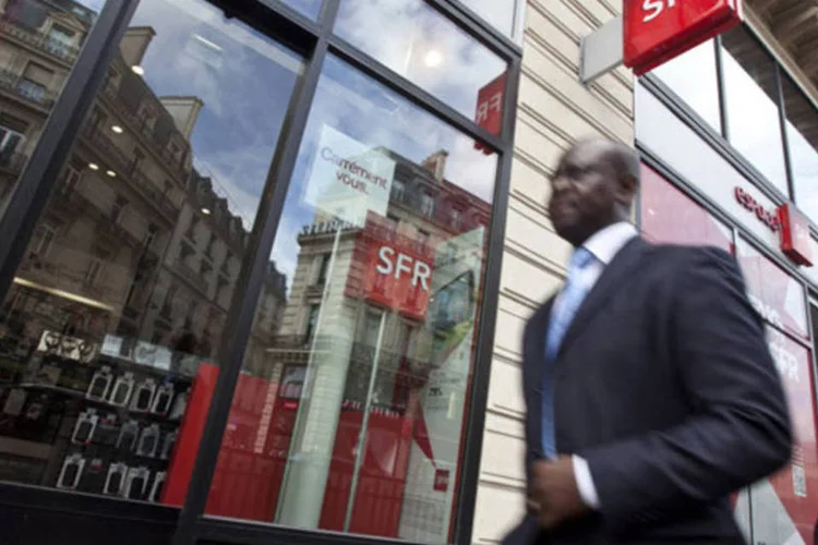 Homem passa em frente a uma loja da SFR, unidade de telefonia móvel da Vivendi, em Paris, na França (Balint Porneczi/Bloomberg)