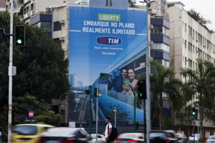Carros passam por um anúncio da TIM em um prédio do Rio de Janeiro (Lianne Milton/Bloomberg)