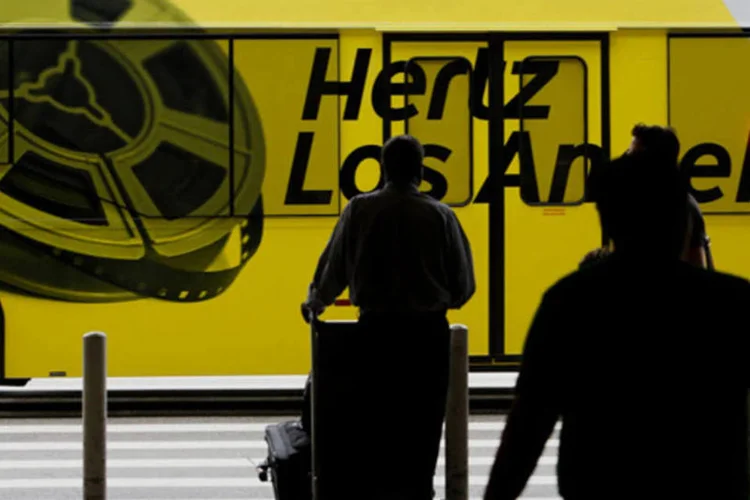 Ônibus da Hertz Global Holdings passa por passageiros no Aeroporto Internacional de Los Angeles, na Califórnia (Patrick T. Fallon/Bloomberg)