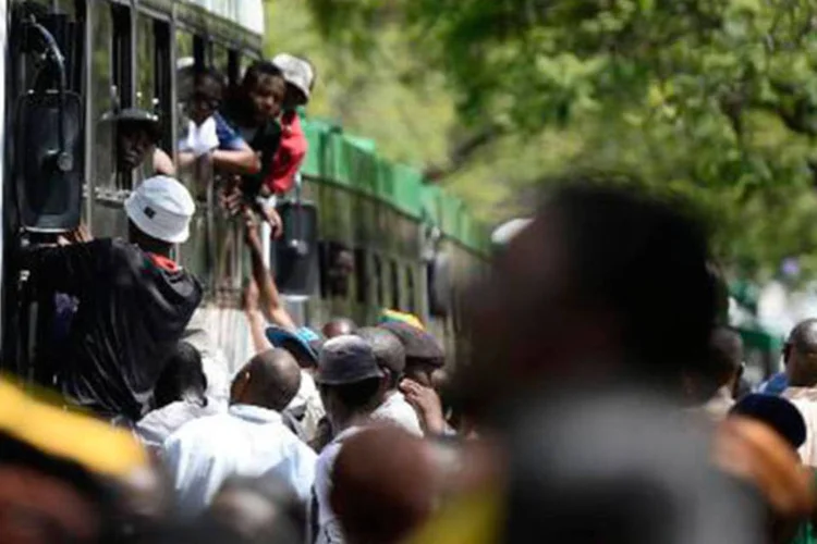 
	Pessoas for&ccedil;am a entrada em um &ocirc;nibus para homenagear Mandela: esta sexta-feira era a &uacute;ltima oportunidade para que as pessoas vissem os restos mortais do ex-presidente
 (STEPHANE DE SAKUTIN/AFP)