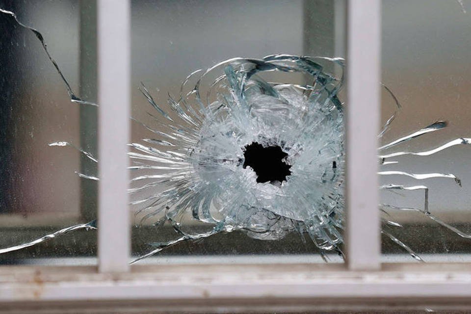
	Impacto de bala &eacute; visto no vidro ap&oacute;s ataque ao escrit&oacute;rio do jornal sat&iacute;rico Charlie Hebdo, em Paris
 (REUTERS/Jacky Naegelen)