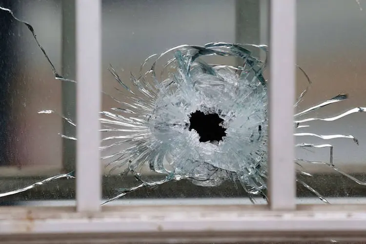 Impacto de bala é visto no vidro após ataque ao escritório do jornal satírico Charlie Hebdo, em Paris  (REUTERS/Jacky Naegelen)