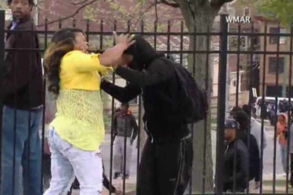 Aos tapas, mãe furiosa retira filho de tumultos em Baltimore