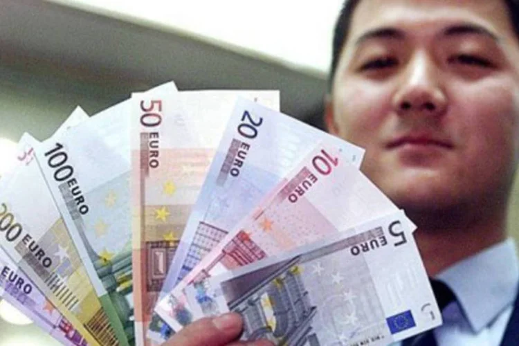Bancário exibe notas de euro em Xangai: país possui US$ 630 bi em títulos europeus (.)