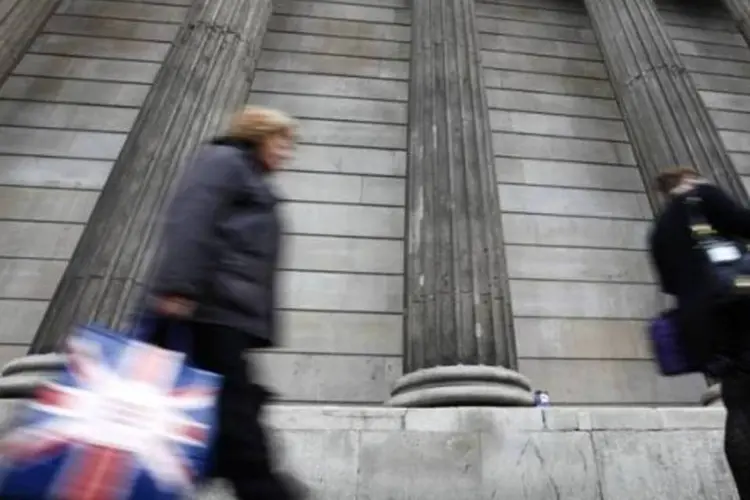 Mulher carregando bolsa decorada com bandeira da Grã-Bretanha passa em frente ao Banco da Inglaterra, em Londres (Andrew Winning/Reuters)
