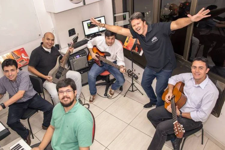 O professor Heitor Castro (de pé), com os alunos de música da Webradar (Márcio Pereira/Divulgação)
