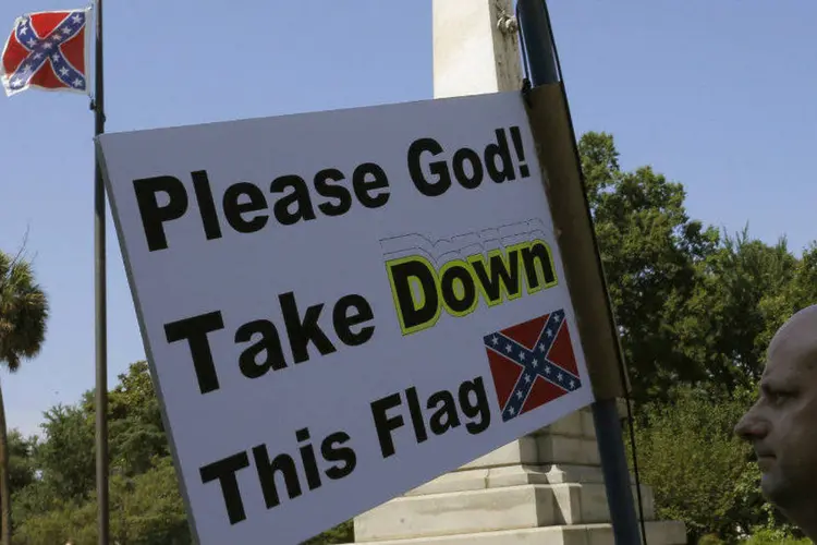 Manifestante segura cartaz pedindo a retirada da bandeira confederada na Carolina do Sul, EUA (Brian Snyder/Reuters)