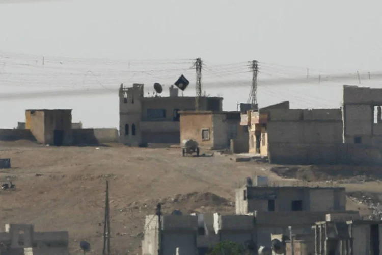 
	Bandeira do EI em Kobani: grupo dominou edif&iacute;cio das for&ccedil;as de seguran&ccedil;a curdas
 (Umit Bektas/Reuters)