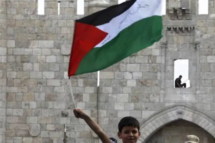 Criança com uma bandeira da Palestina com um guarda ao fundo: resolução ainda longe de acontecer (Lior Mizrahi/Getty Images)