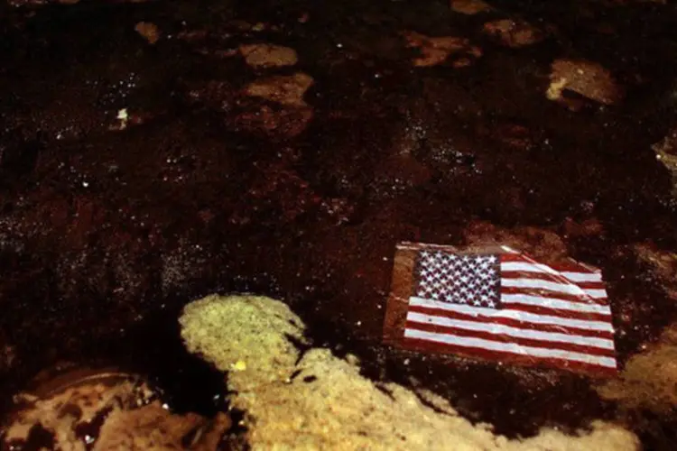 Bandeira americana em meio ao óleo vazado da Deepwater Horizon, no Alabama: a Transocean concordou em se declarar culpada de violar a Lei de Água Limpa no desastre (Joe Raedle/AFP)