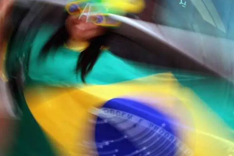 
	Mulher segura bandeira do Brasil: no longo prazo, por&eacute;m, o Brasil segue entre os pa&iacute;ses mais otimistas
 (Getty Images)