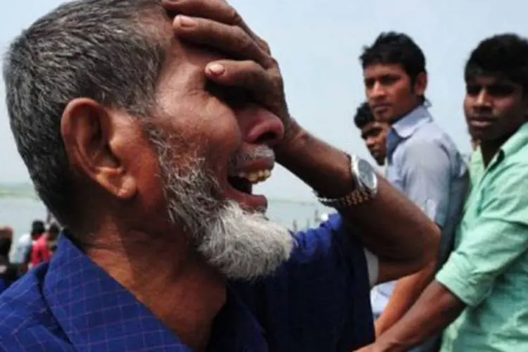 Homem chora enquanto resgate prossegue em Bangladesh: a estimativa é que entre 150 e 200 pessoas estejam desaparecidas (AFP)