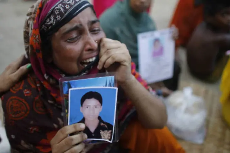 Parente de vítima desaparecida no desabamento de prédio em Bangladesh chora enquanto aguarda notícias no local (REUTERS/Andrew Biraj)