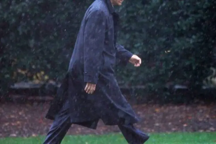 
	Barack Obama anda agasalhado na chuva, perto da Casa Branca
 (Jason Reed/Reuters)