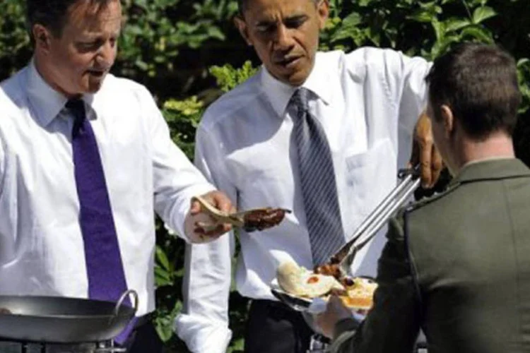 Barack Obama e David Cameron servem churrasco  (Jewel Samad/AFP)