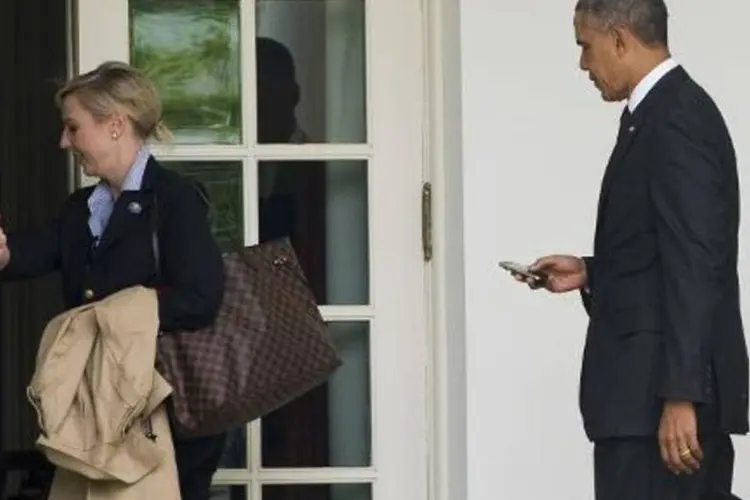 Barack Obama entra na ala leste da Casa Branca junto à chefe da equipe de operações, Anita Decker (Saul Loeb/AFP)