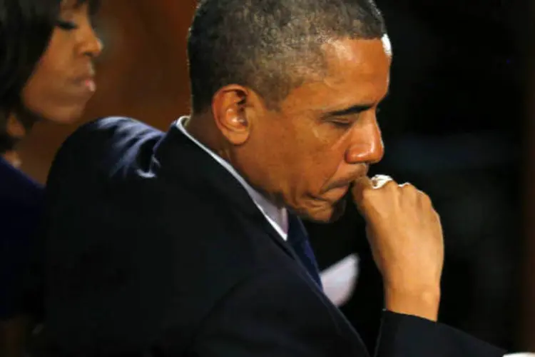 O presidente norte-americano, Barack Obama, e a primeira-dama, Michelle Obama, ao fundo, oram pelas vítimas do ataque a Boston. (REUTERS/Brian Snyder)