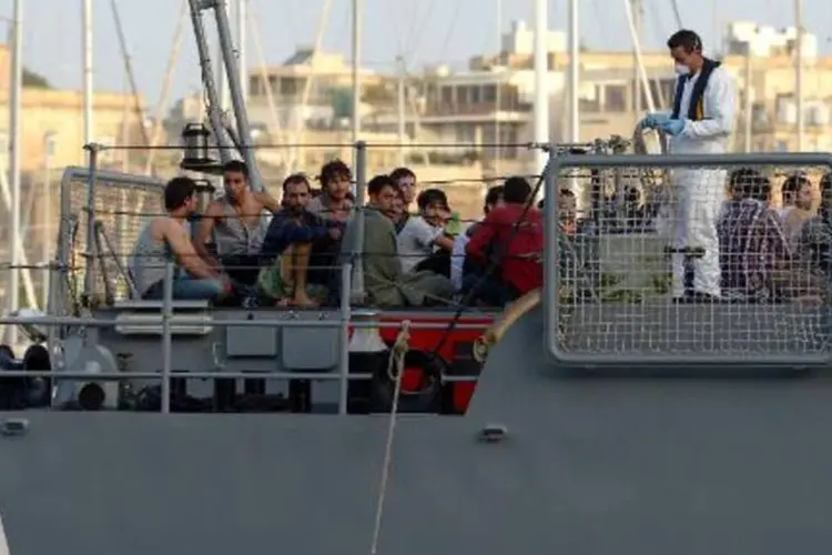 Imigrantes em barco de patrulha: naufrágio teria sido provocado por traficantes (Matthew Mirabelli/AFP)