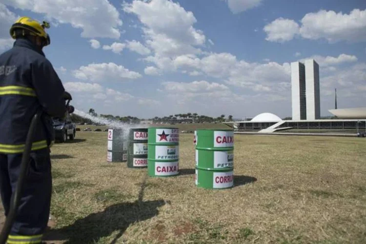 Bombeiros e policiais legislativos recolhem barris usados em protesto em Brasília (Marcelo Camargo/Agência Brasil)