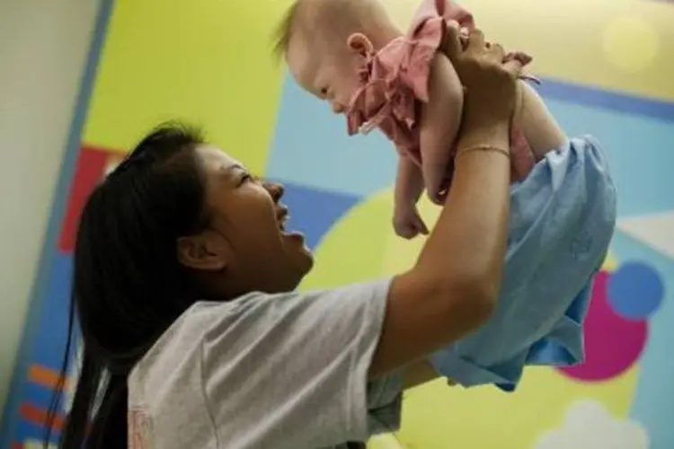 Pattaramon brinca com o bebê Gammy no hospital: ela afirmou que não abandonará criança com Síndrome de Down (Nicolas Asfouri/AFP)