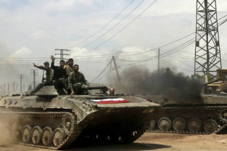 Tropas sírias entram na localidade de Dumayna, em 13 de maio de 2013 (AFP / Joseph Eid)