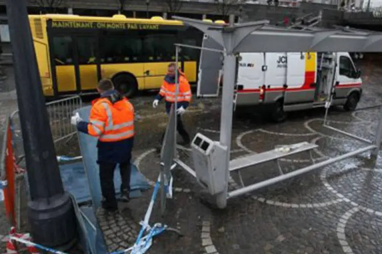 Policiais retiram marquise de ponto de ônibus que foi danificada durante ataque à Praça Saint-Lambert: cinco pessoas morreram, entre elas o autor dos assassinatos, que se suicidou (Michel Krakowski/AFP)