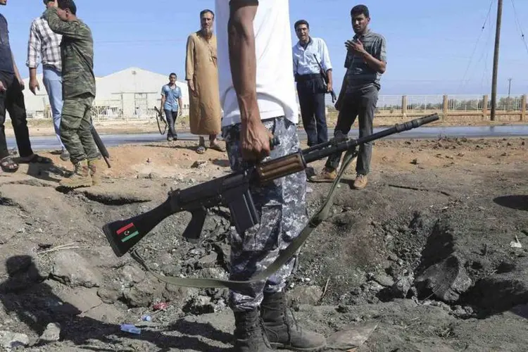 
	Homem armado no local de uma explos&atilde;o em Barsis, no leste de Benghazi
 (Esam Omran Al-Fetori/Reuters)