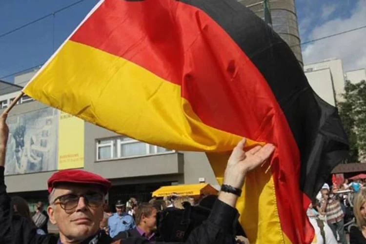 
	Homem segurando bandeira alem&atilde;: pesquisas revelam um maior otimismo por parte de empresas, investidores e consumidores
 (Getty Images)