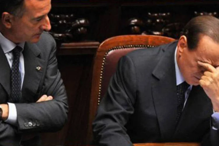 O primeiro-ministro Silvio Berlusconi (D) e o chefe da diplomacia Franco Frattini discutem a situação financeira italiana (Alberto Pizzoli/AFP)