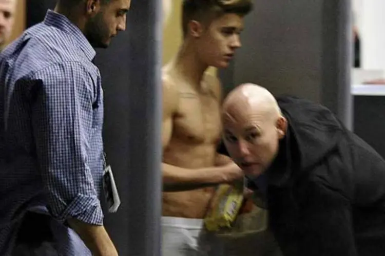 Seguranças tentam tampar a visão do astro pop Justin Bieber em aeroporto em Lodz (Tomasz Stanczak/Agencja Gazeta/Reuters)