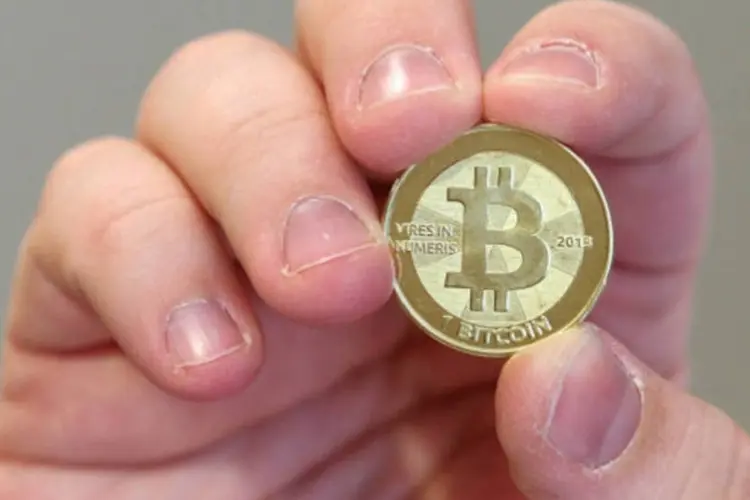 Mão segura uma bitcoin (Getty Images)
