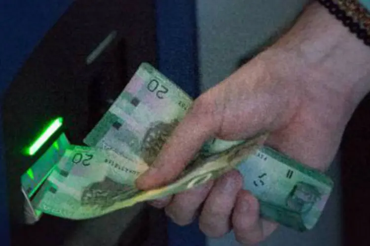 
	Um usu&aacute;rio insere a moeda canadense para trocar por bitcoins: &quot;&Eacute; a moeda da internet, t&atilde;o real como qualquer outra&quot;, explica Demeter, um dos donos
 (AFP)