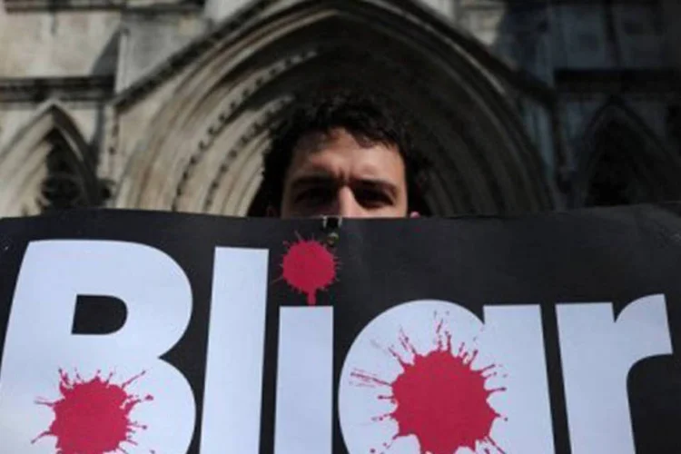 Manifestante exibe cartaz que faz um trocadilho entre o nome de Blair e o termo mentiroso (em inglês,  (Carl Court/AFP)