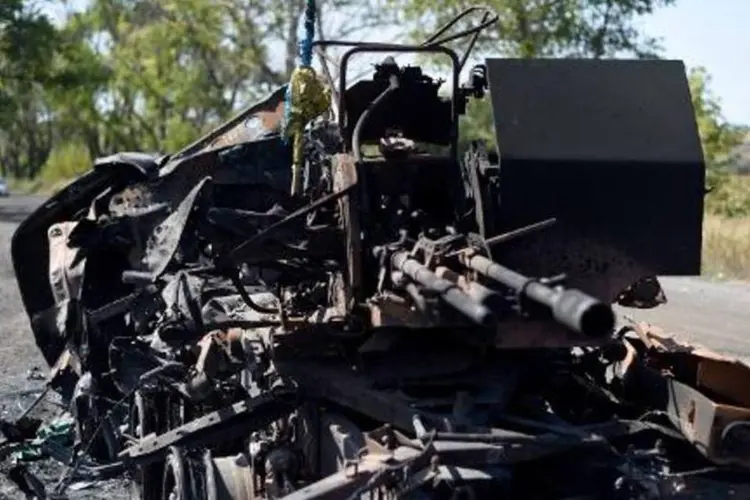 Veículo blindado destruído é visto ao lado da estrada que leva a Ilovaisk, na Ucrânia (Francisco Leong/AFP)