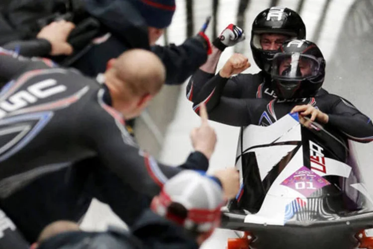 Time dos EUA de bobslead comemoram enquanto passam pela linha de chegada de uma competição nos Jogos Olímpicos de Inverno, em Sochi (Fabrizio Bensch/Reuters)