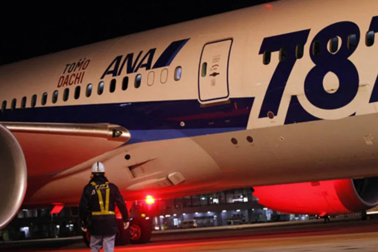 Funcionário do aeroporto caminha próximo de um avião Boeing 787 Dreamliner da All Nippon Airways (ANA) no Novo Aeroporto Internacional de Tóquio (Shohei Miyano/Reuters)