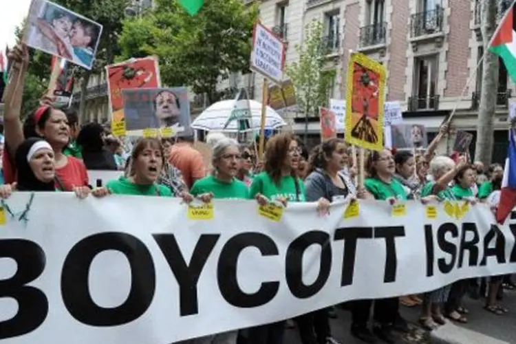 Manifestantes seguram uma faixa onde se lê "Boicotem Israel", durante um protesto a favor da Palestina (Dominique Faget/AFP)