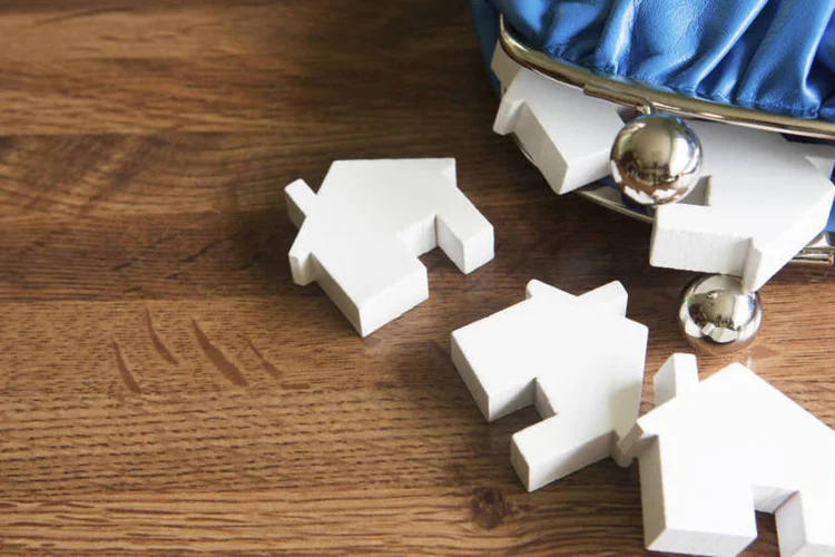 
	Bolsinha de moedas com casas em miniatura: Mesmo com juros mais altos, im&oacute;veis t&ecirc;m sido vendidos com descontos
 (ThinkStock/Daisy-Daisy)